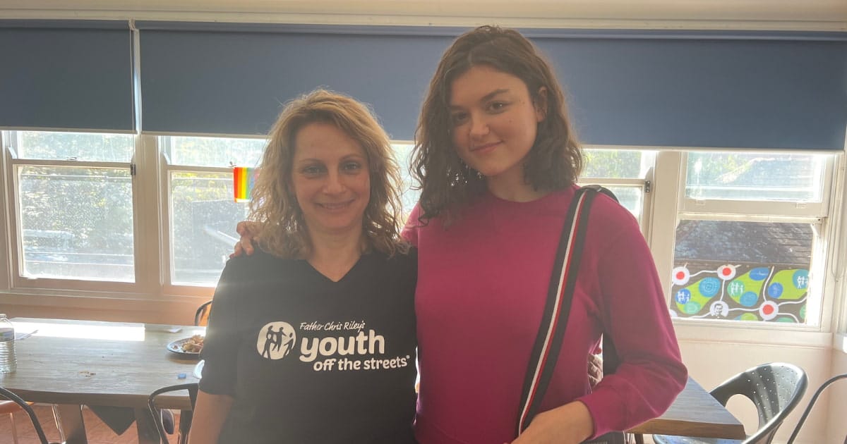 Male youth worker welcoming a teenage girl to a refuge