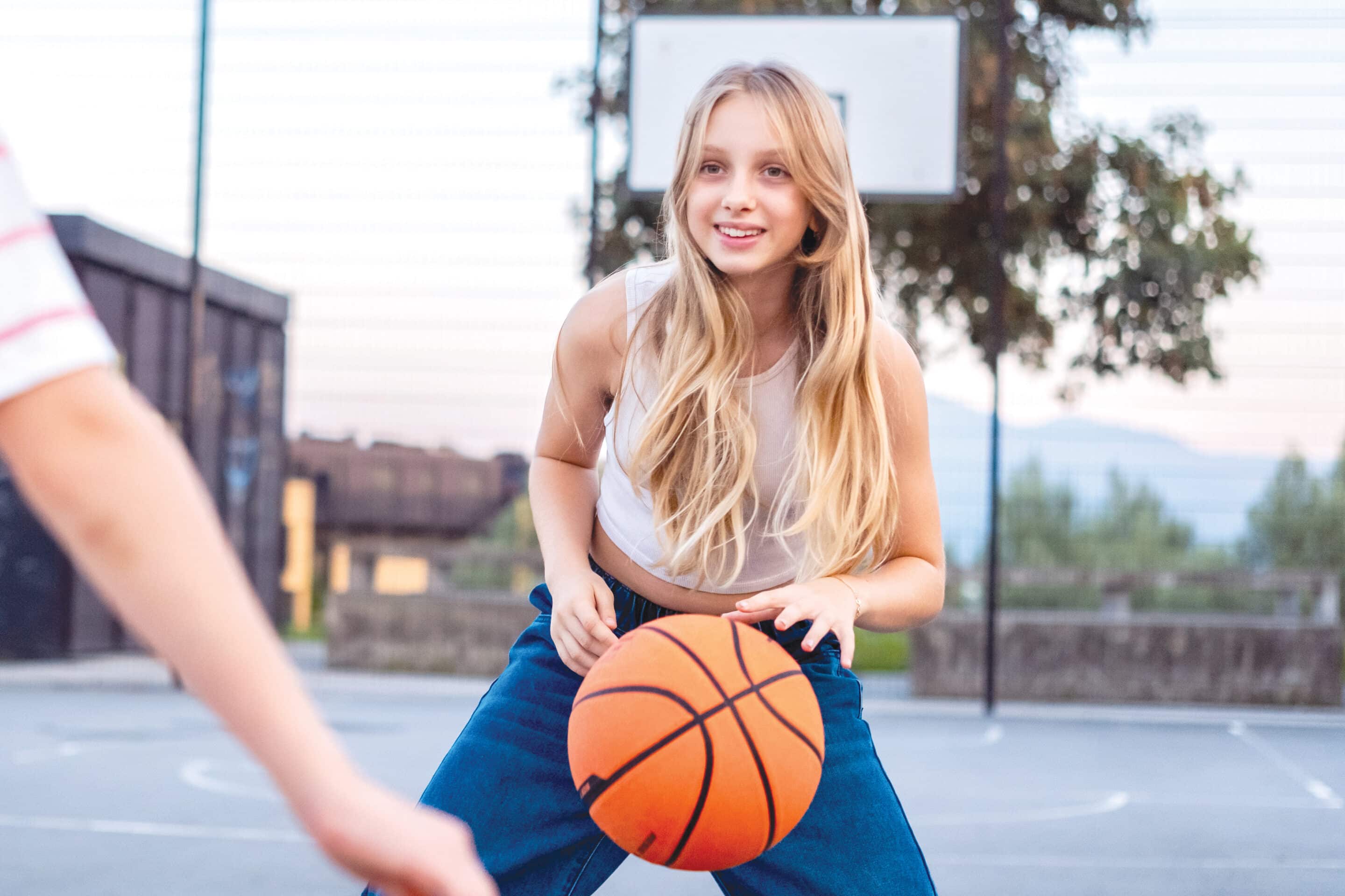Kids Playing Basketball on Outdoor Court Female teacher standing beside teenage, male Youth Off The Streets student
